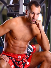 Hunk posing in a gym