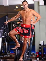 Hunk posing in a gym